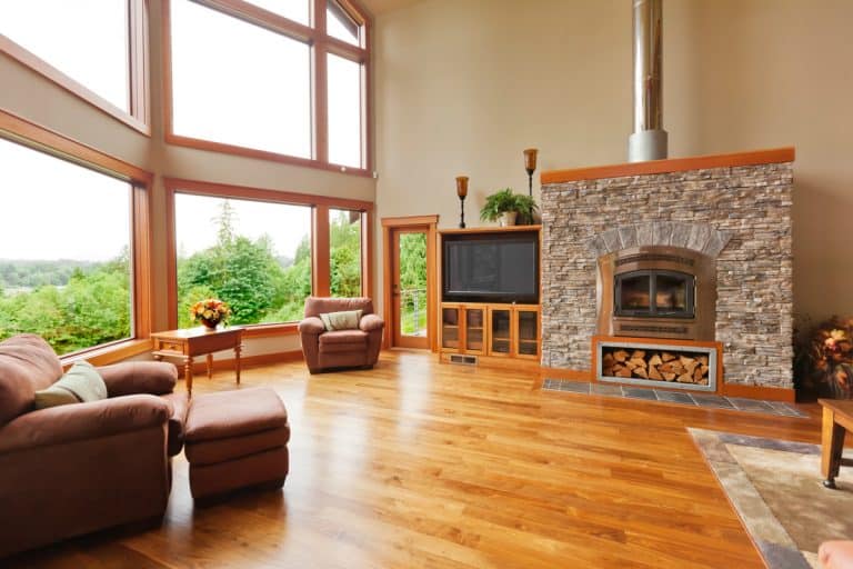 A modern luxury house with laminated woo flooring with laminated wooden flooring decorative stone covered fireplace mantel and incorporated with a small ottoman laminated wooden lm, Is Wood Laminate Flooring Real Wood? Here's what you need to know