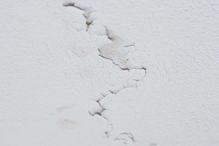Cracked ceiling with peeling layer due to water leak, 6 Types of Ceiling Cracks Homeowners Should Know