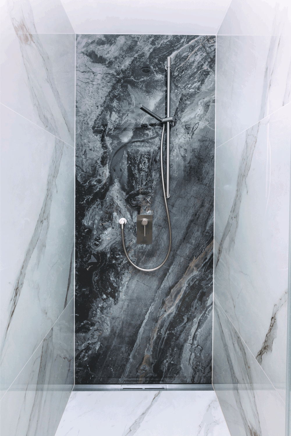 Linear shower drain in modern bathroom. Big marble tile format