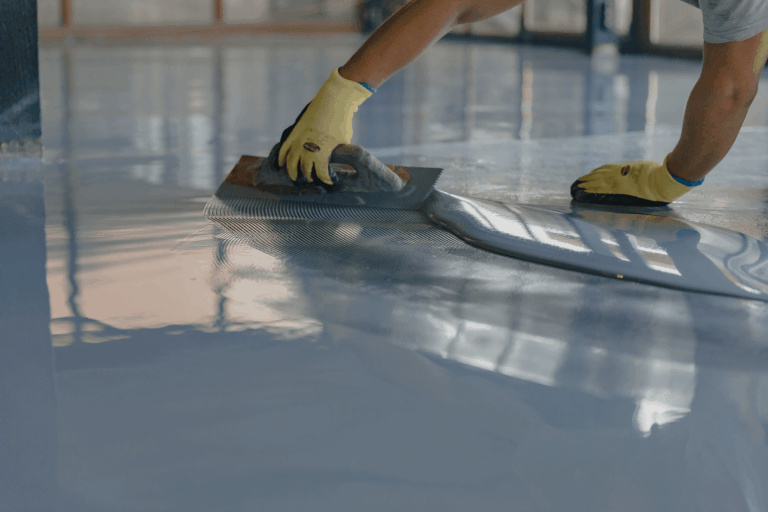 A worker applying epoxy on the stadium or gym floor, Can You Epoxy A Wood Floor?
