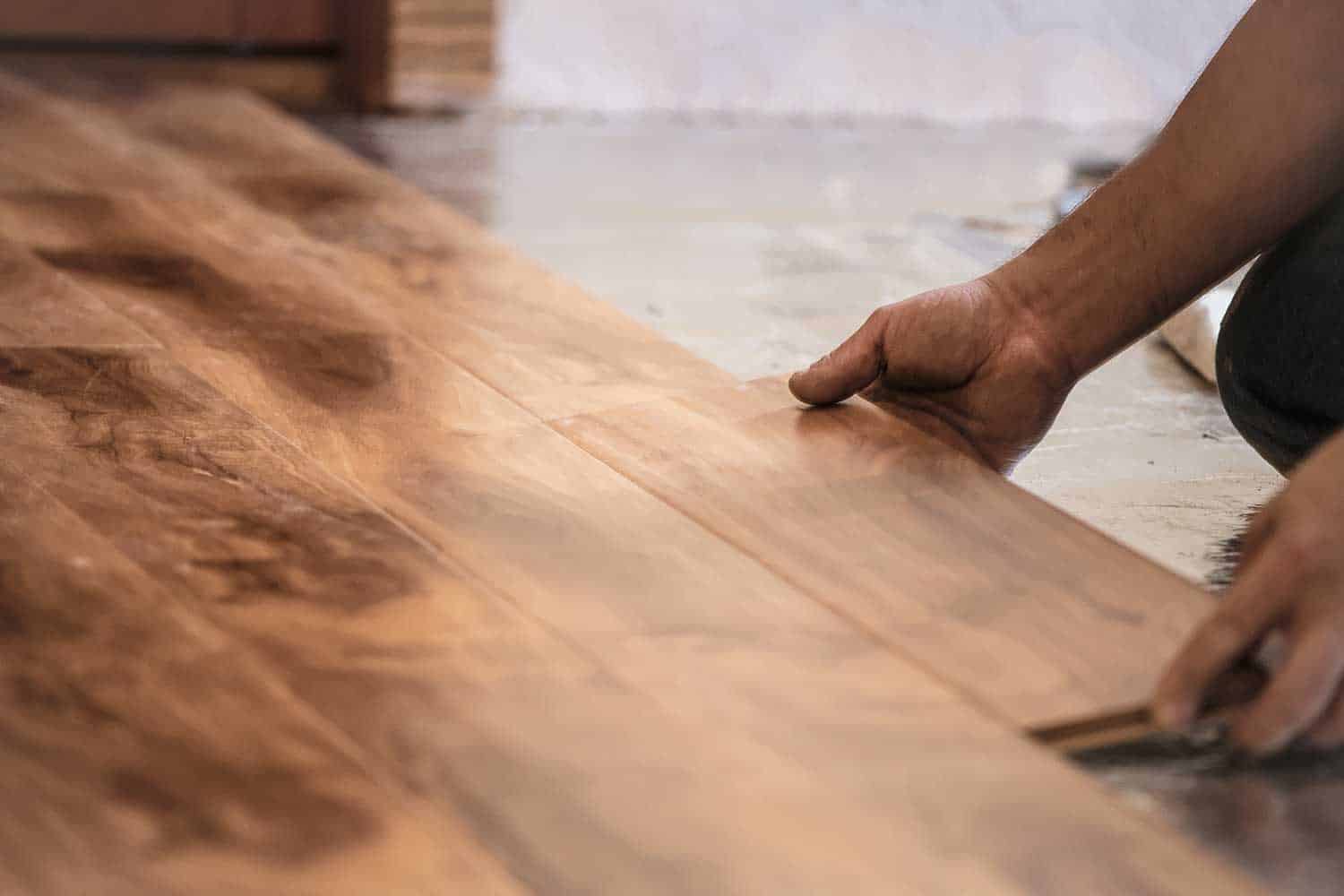 Man installing wood flooring in home