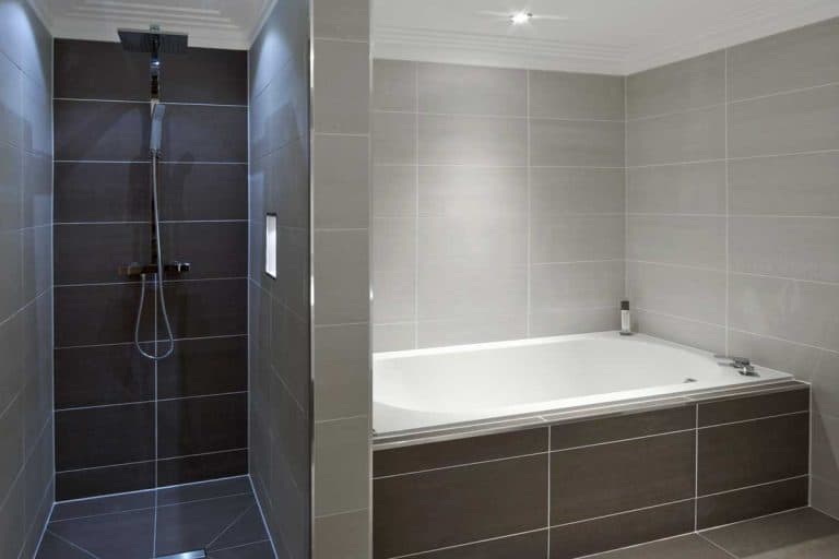 A bath and shower cubilcle, beautifully lined with two toned gray marble tiles, What Color Grout To Use With Gray Tile?