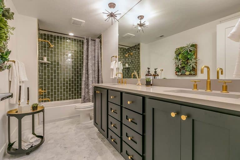 A teal and luxurious bathroom with green cabinetry, green backsplash, and a huge mirror on the vanity, Should The Backsplash Grout Match Floor Grout?