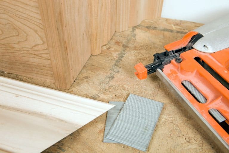 A cherry colored brad nailer used in installing baseboards, Can You Use A Brad Nailer For Baseboards?