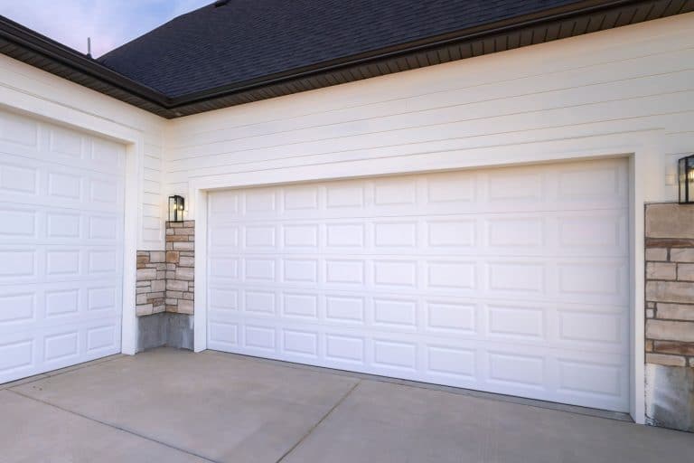 A white long span garage door, How To Keep A Garage Door From Sticking To A Concrete Floor