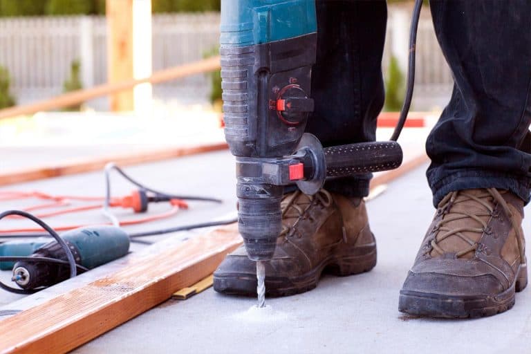 A man drilling into concrete floor, How To Drill Into Concrete Floor