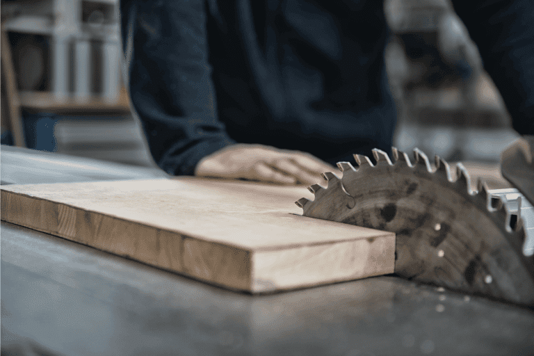 A-man-operating-a-table-saw-in-a-woodworking-shop.-How-To-Cut-Hardwood-Flooring-Around-Door-Jambs