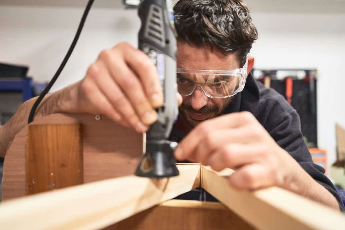 A skilled worker making his carpentry project using a dremel tool