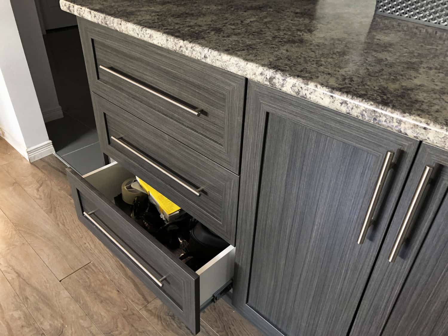 Modern dark gray aluminum and marble composed cabinet with open drawer door