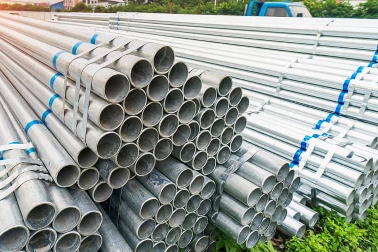 Steel pipes stacked in factory warehouse, How Long Do Galvanized Steel Pipes Last?