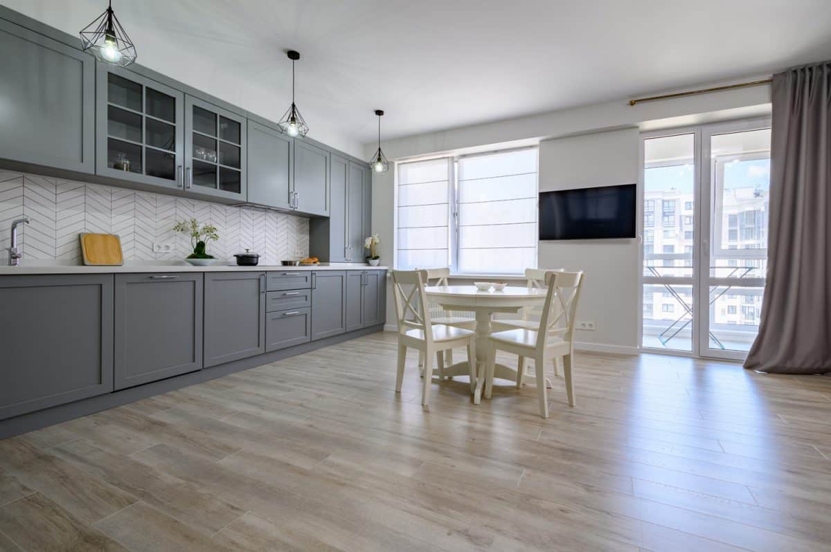 Trendy grey and white modern kitchen furniture showcase in studio apartment