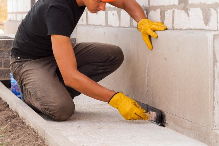 Man painting house foundation, How To Cover Up A High House Foundation