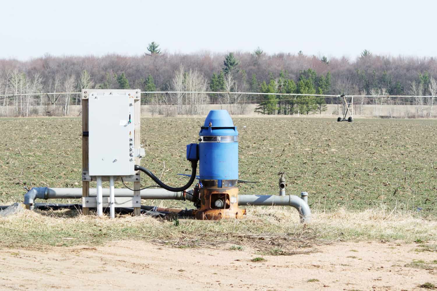 A blue colored irrigation well pump in the field