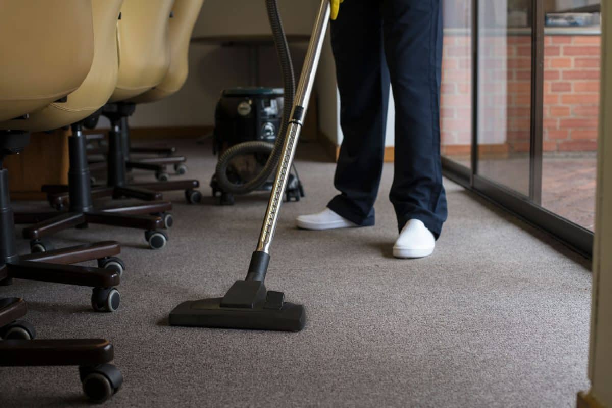 A janitor cleaning the carpet