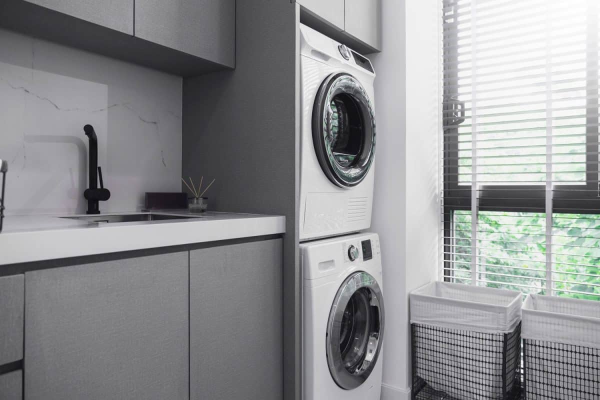 A washing machine and a dryer on top of it in the laundry room