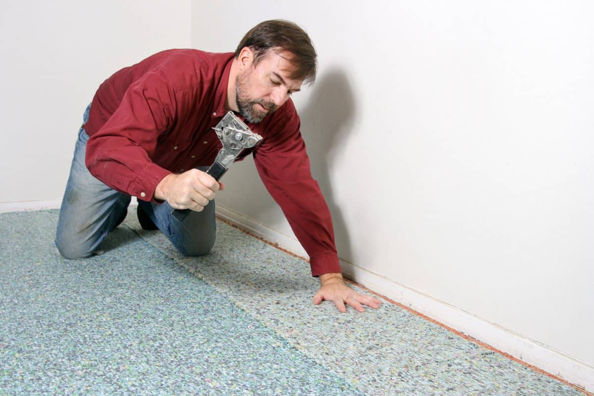 A worker installing a carpet padding in the living room