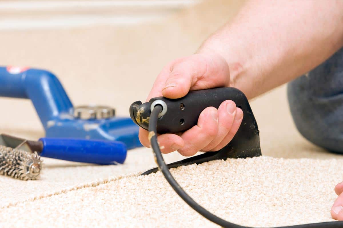 Carpet Installer joining two pieces with seam iron