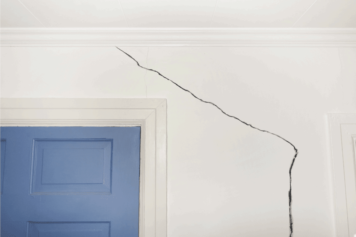 Crack in the wall of a home near door and door jamb. 5 Types Of Cracks In Walls [What Homeowners Need To Know]