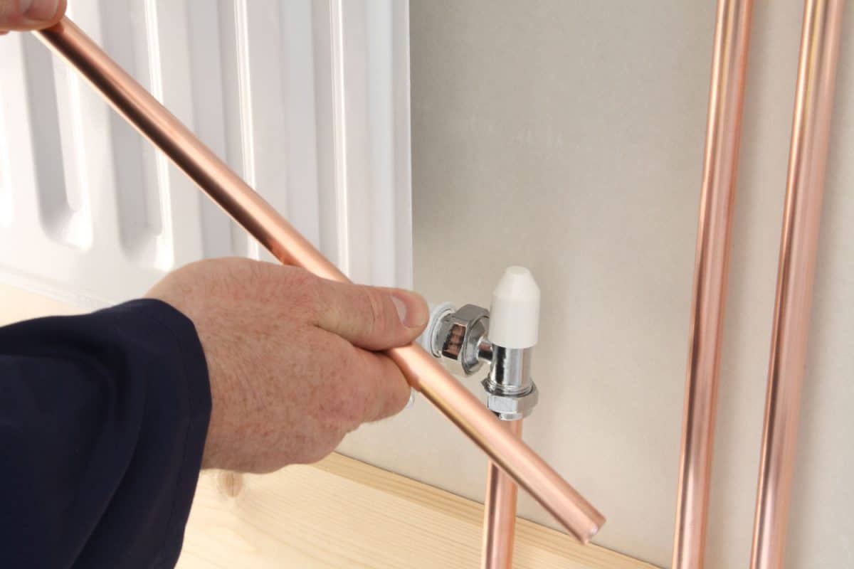 Plumber installing a new central heating radiator.