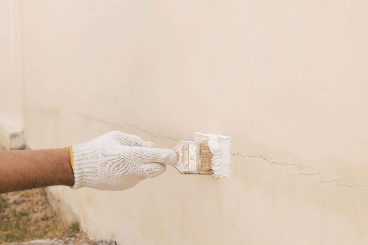 Repairing a crack in the wall using a white colored sealant
