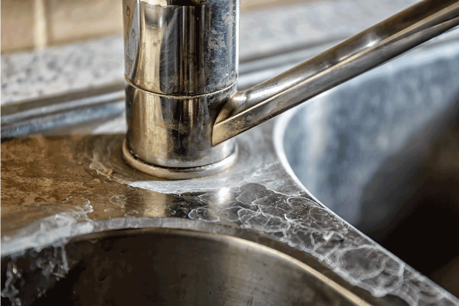 kitchen tap and sink with hard water calcification.