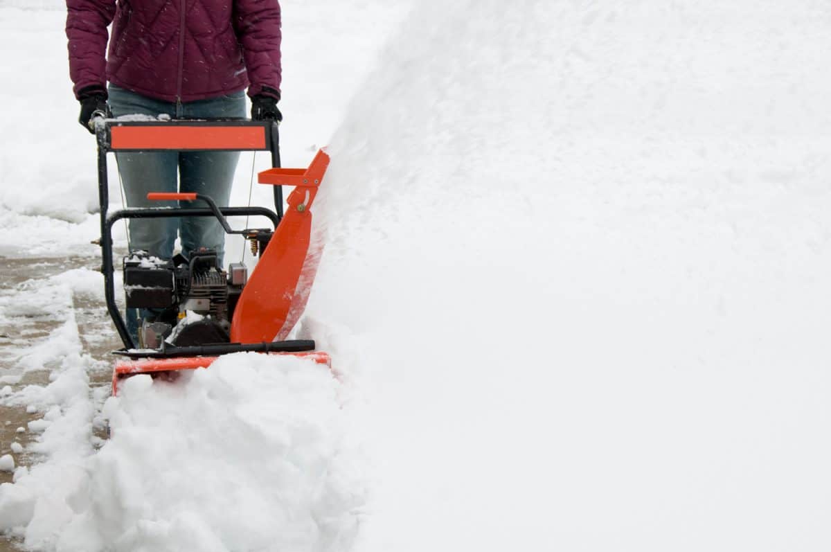 "woman walking behind a snow blower, sending a plume of fresh snow into the cold winter air.See more related images in my Winter Snow Removal lightbox
