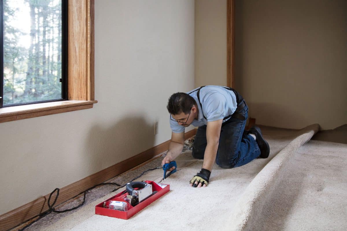 A carpet installer using a seaming iron in the carpet