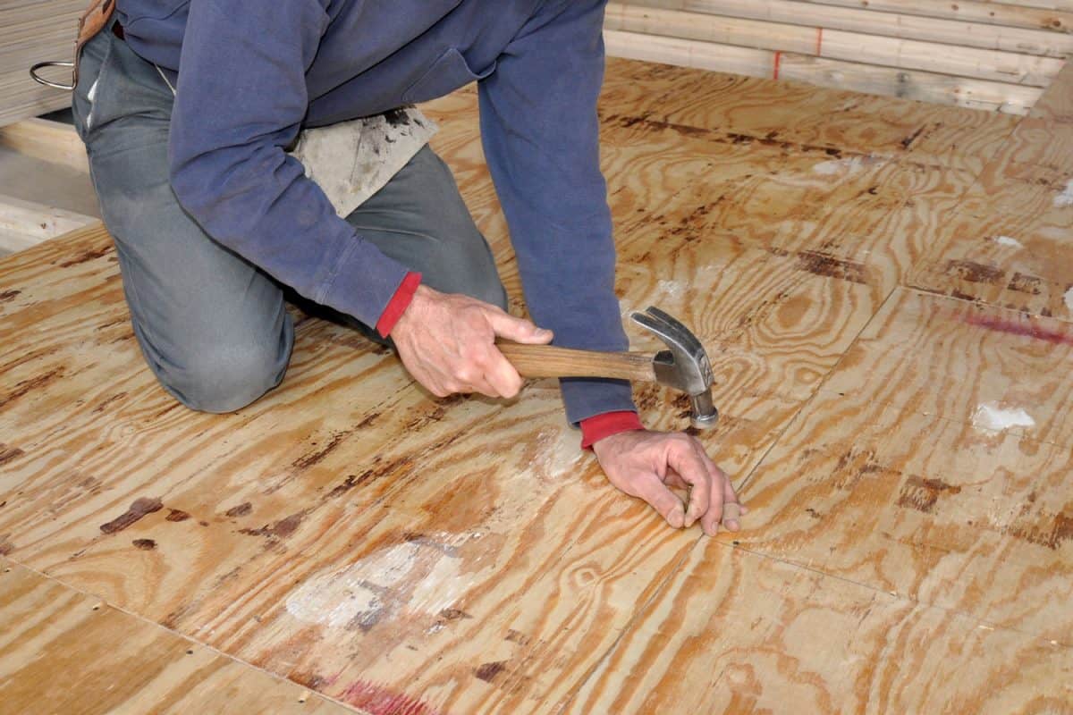 A worker installing a new underlayment for the living room floor