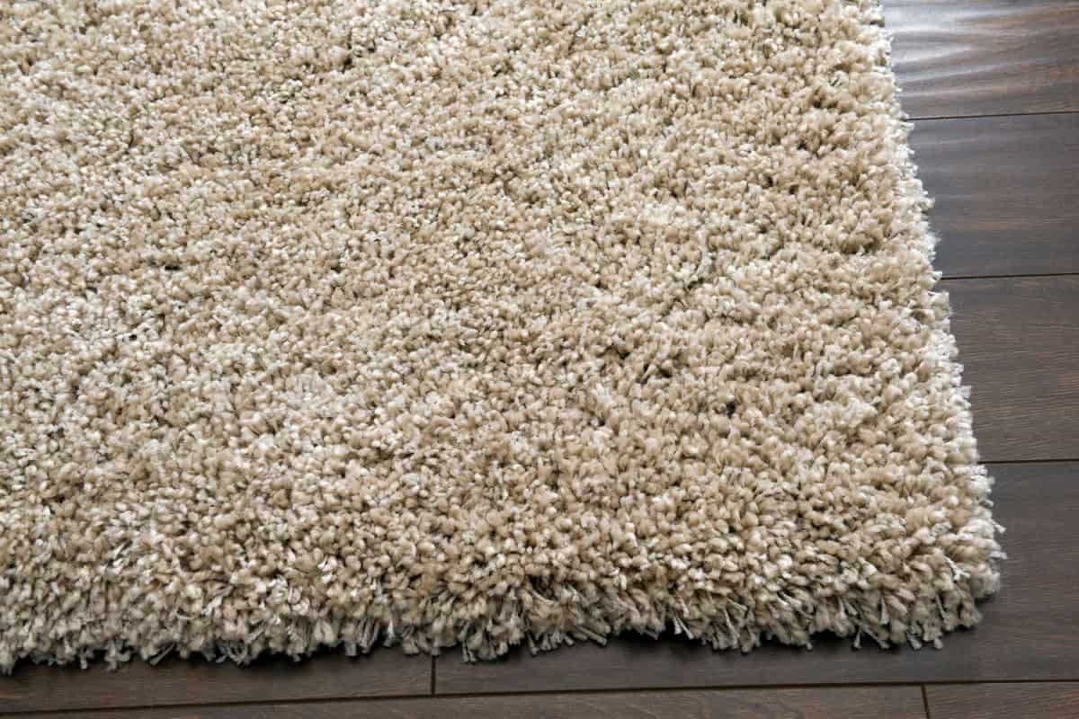 An up close photo of a hard carpet on the wooden flooring