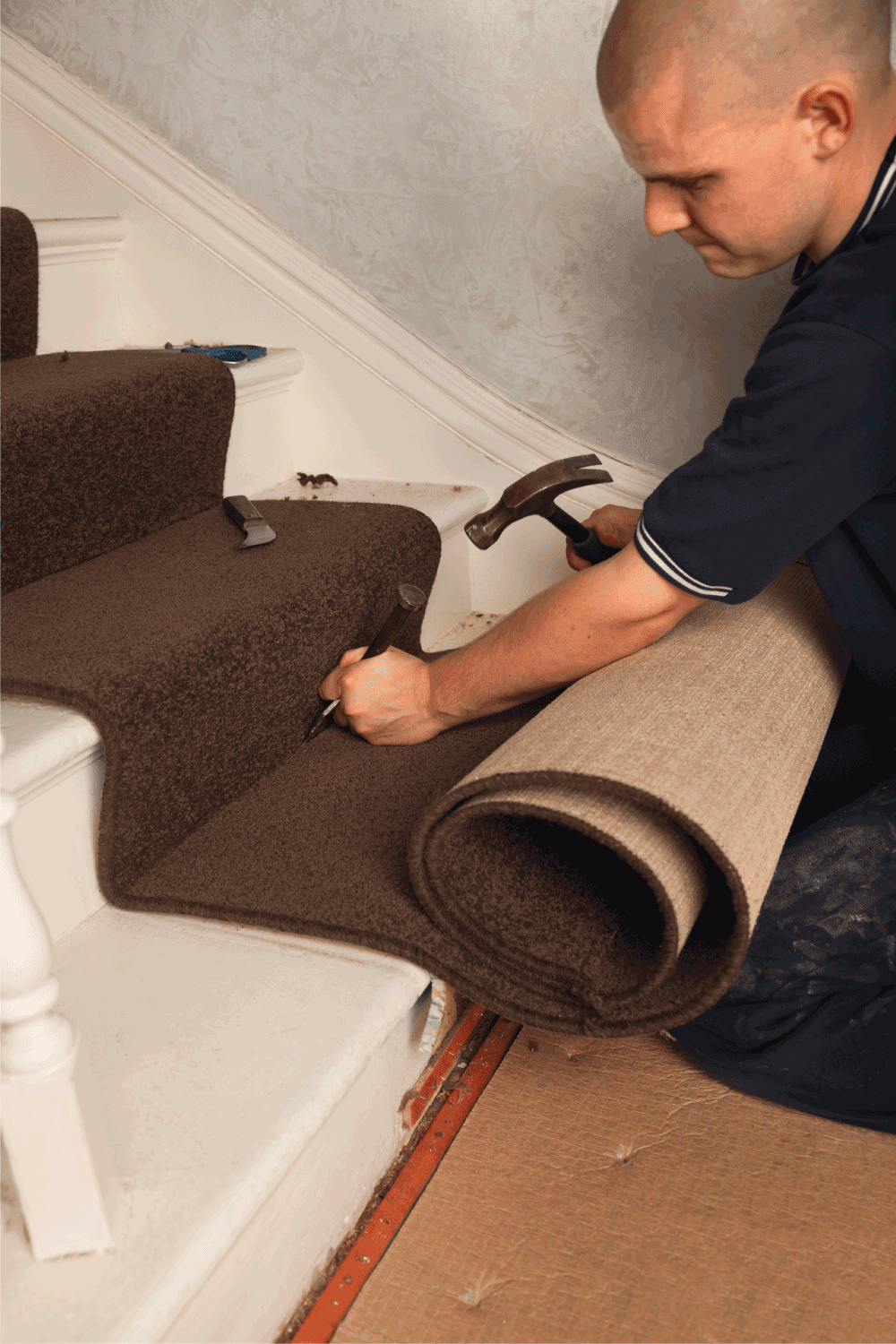 Carpet Fitter using tucking tool on stairs