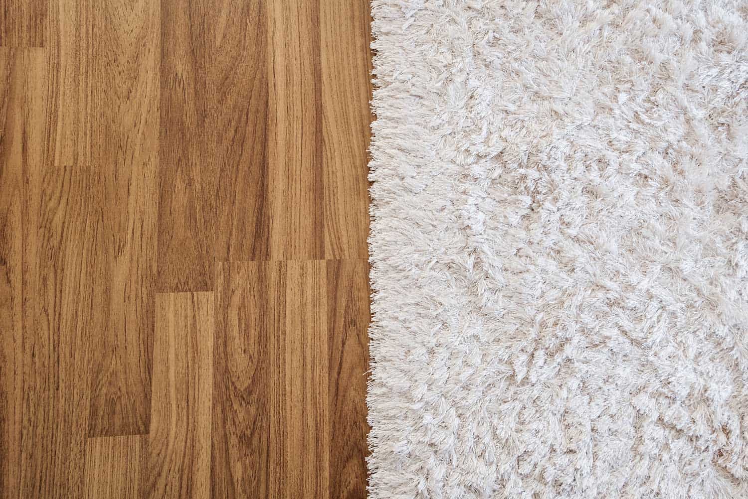 Close-up luxury white carpet on laminate wood floor in living room