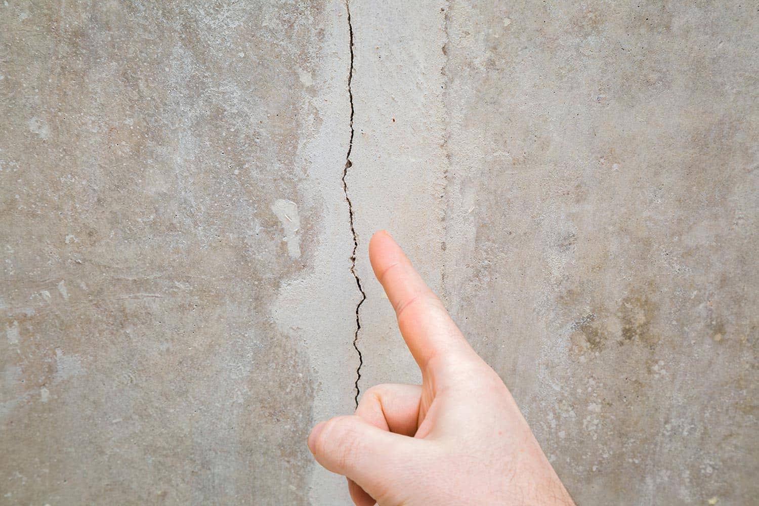 Finger pointing to cracked ceiling