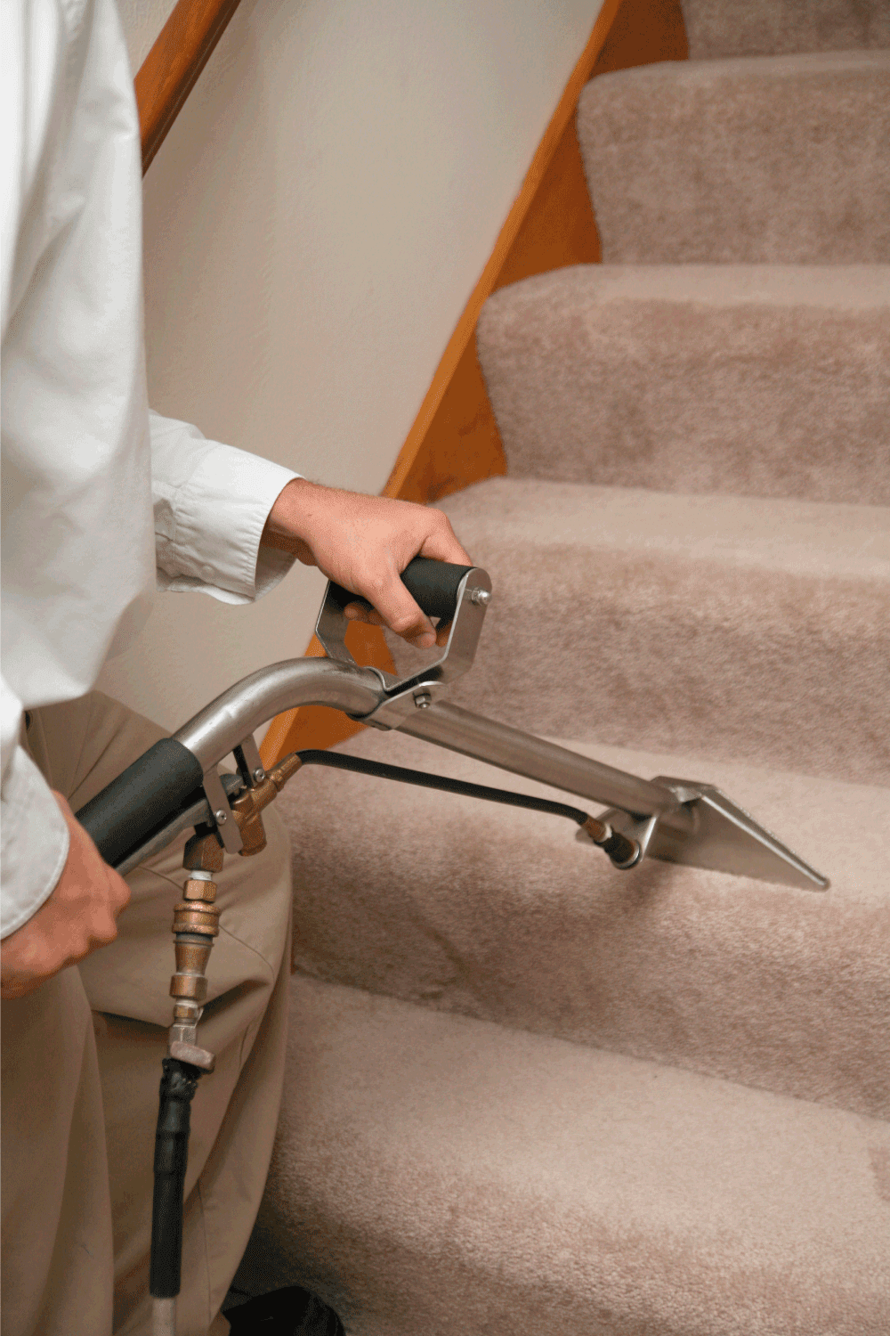 Man cleaning carpeted staircase.
