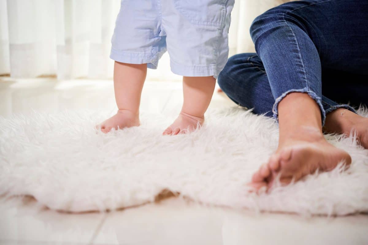Mother and baby walking on newly cleaned carpet