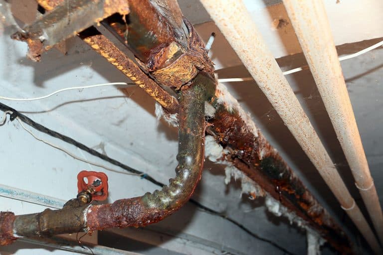 Old rusty water pipes and sewerage of a residential building, Do Copper Pipes Corrode Or Rust [And How To Prevent It]