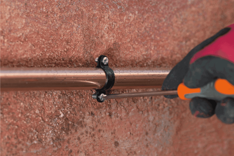 Operator-tightening-a-screw-on-the-gas-line.-Can-You-Plaster-Or-Cement-Over-Copper-Pipes