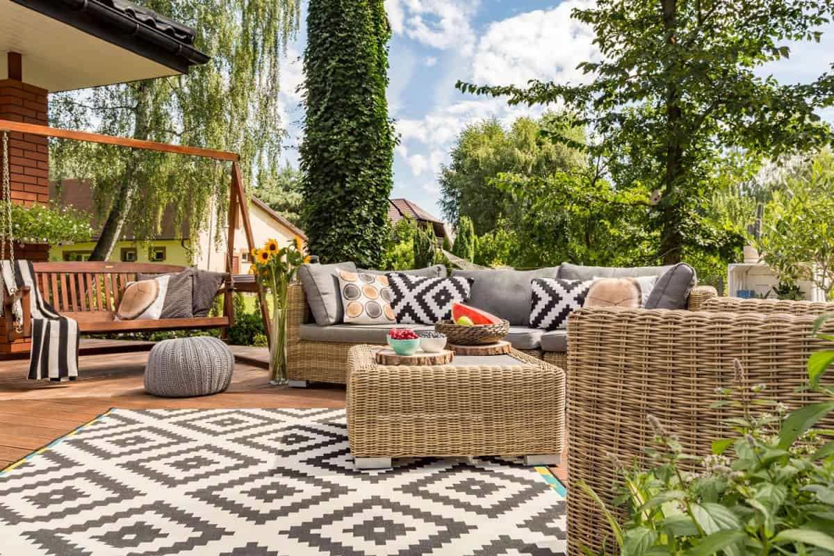 Wicker chairs outside a modern design patio with a black and white patterned carpet