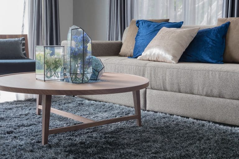modern living room with wooden round table on carpet, What Material Slides Best On Carpet?