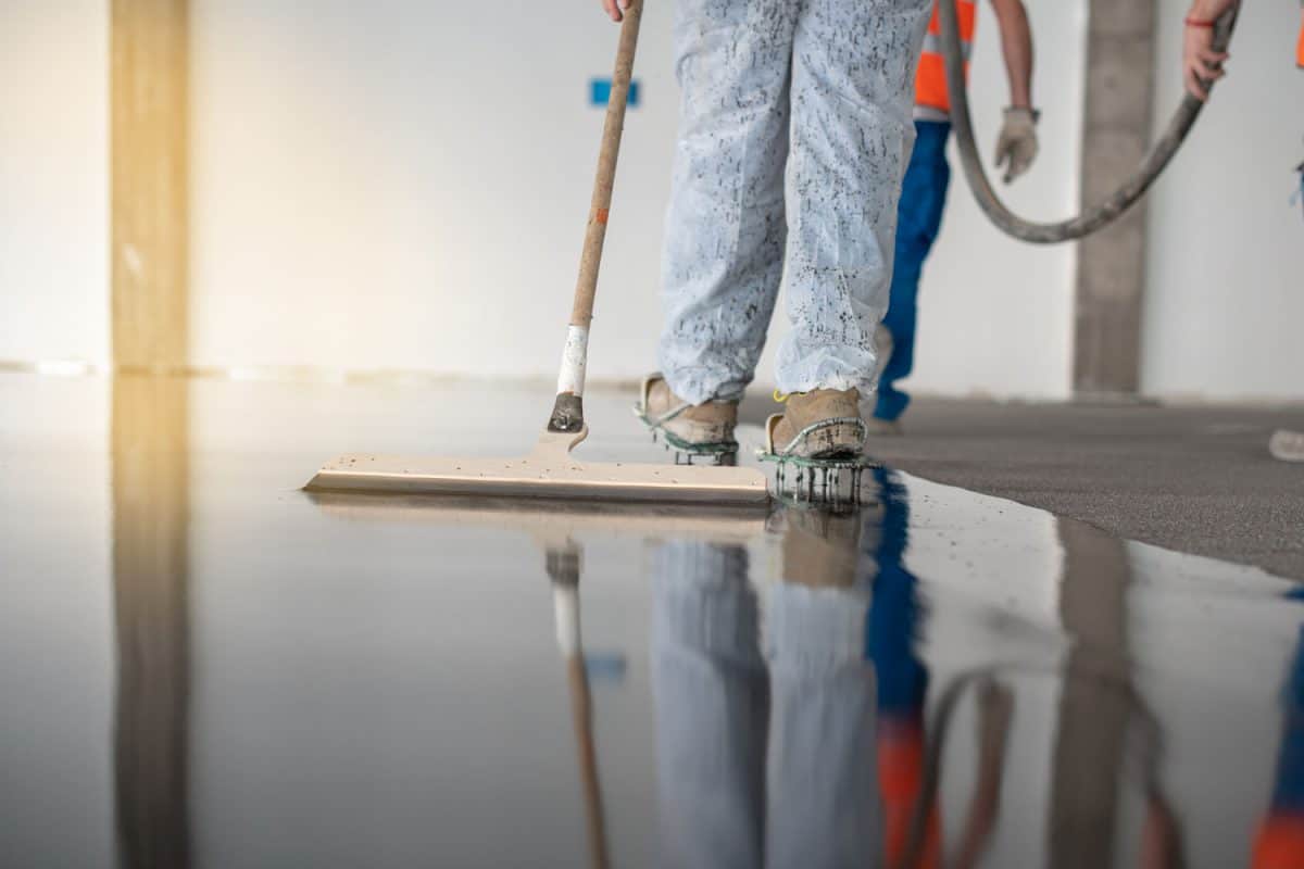 A worker spreading epoxy on the commercial floor