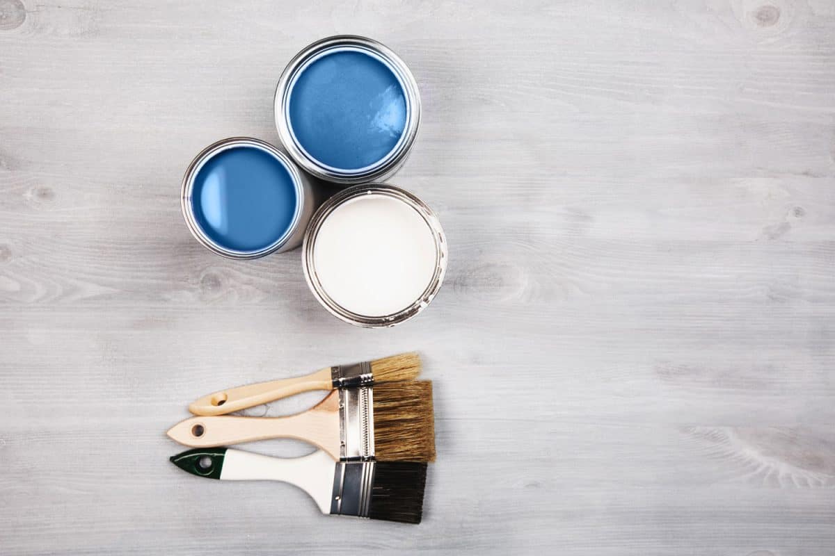 Blue and white paint with a brush on the floor