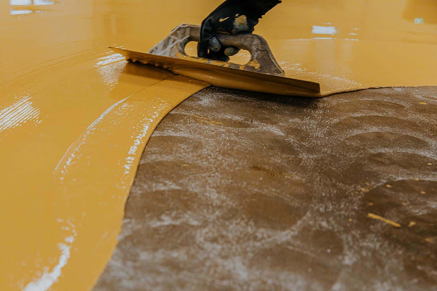Coating floor with self-leveling epoxy resin in industrial workshop