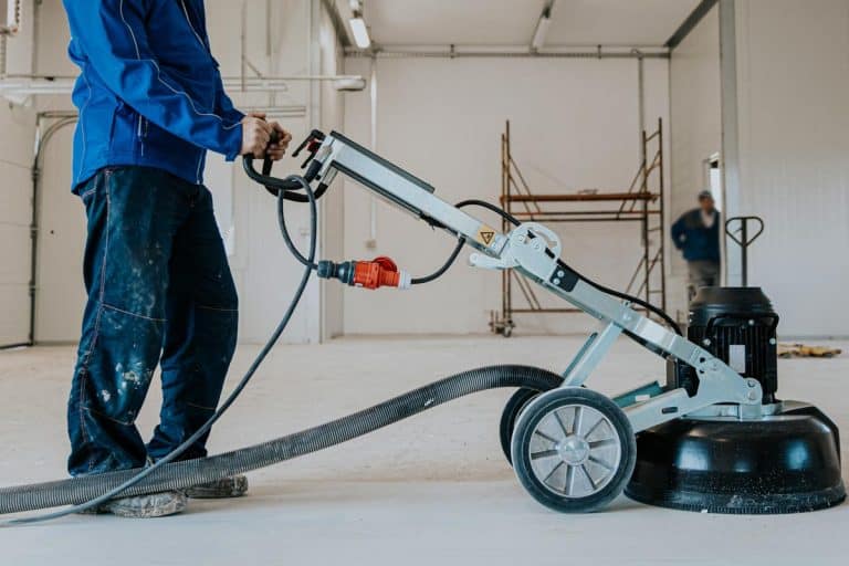 A construction worker using machine polishing surface floor for smoothing epoxy concrete in the factory, How To Keep Epoxy Floors Shiny [4 Methods To Consider]