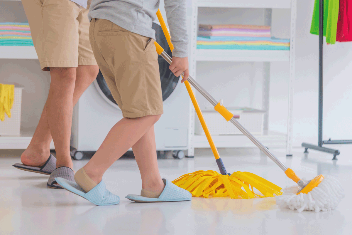 Father and Son is cleaning the home floor together using yellow mop. Can You Use Bleach On Epoxy Floor