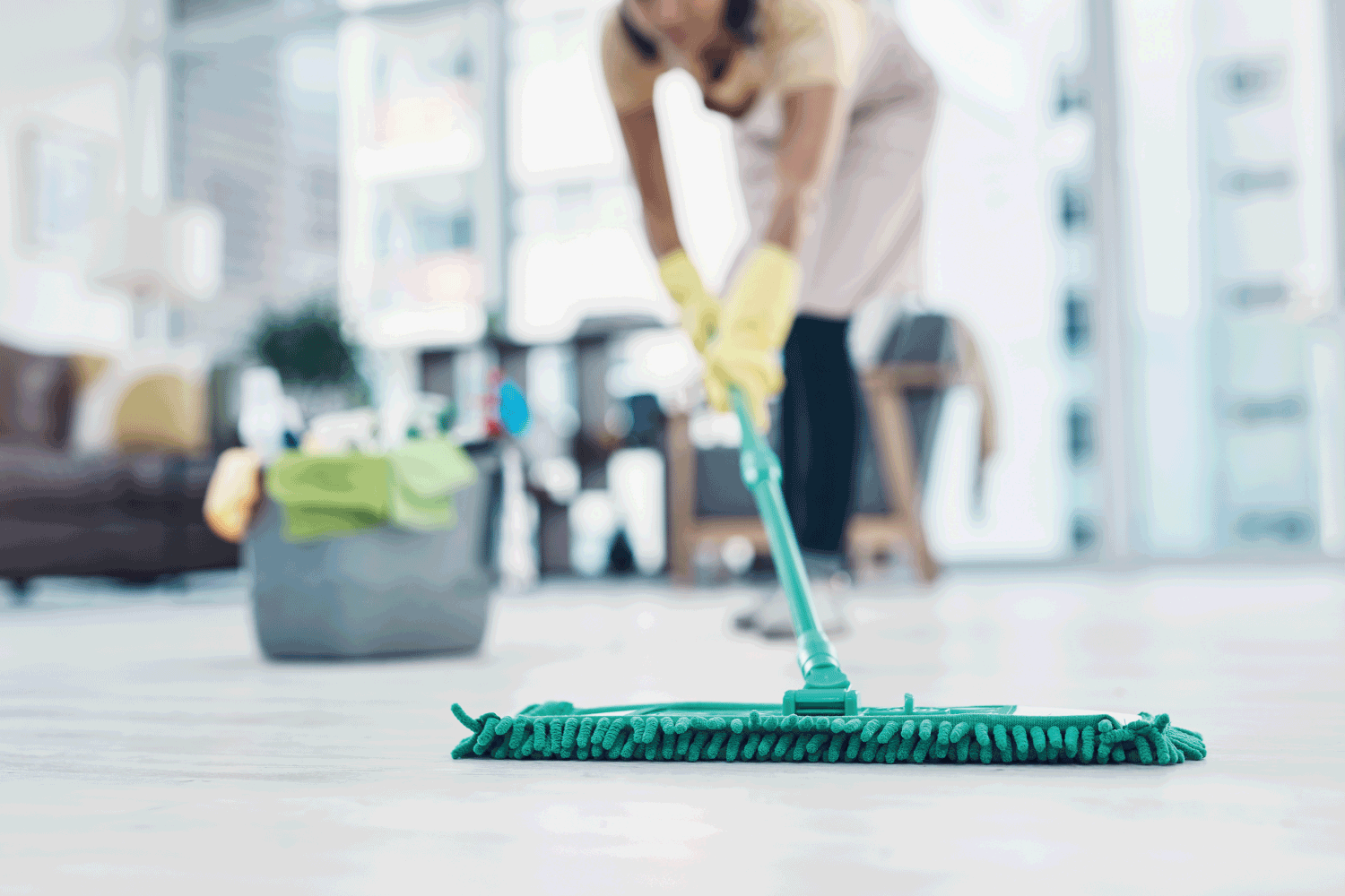 Shot of an unrecognisable woman mopping the floor at home