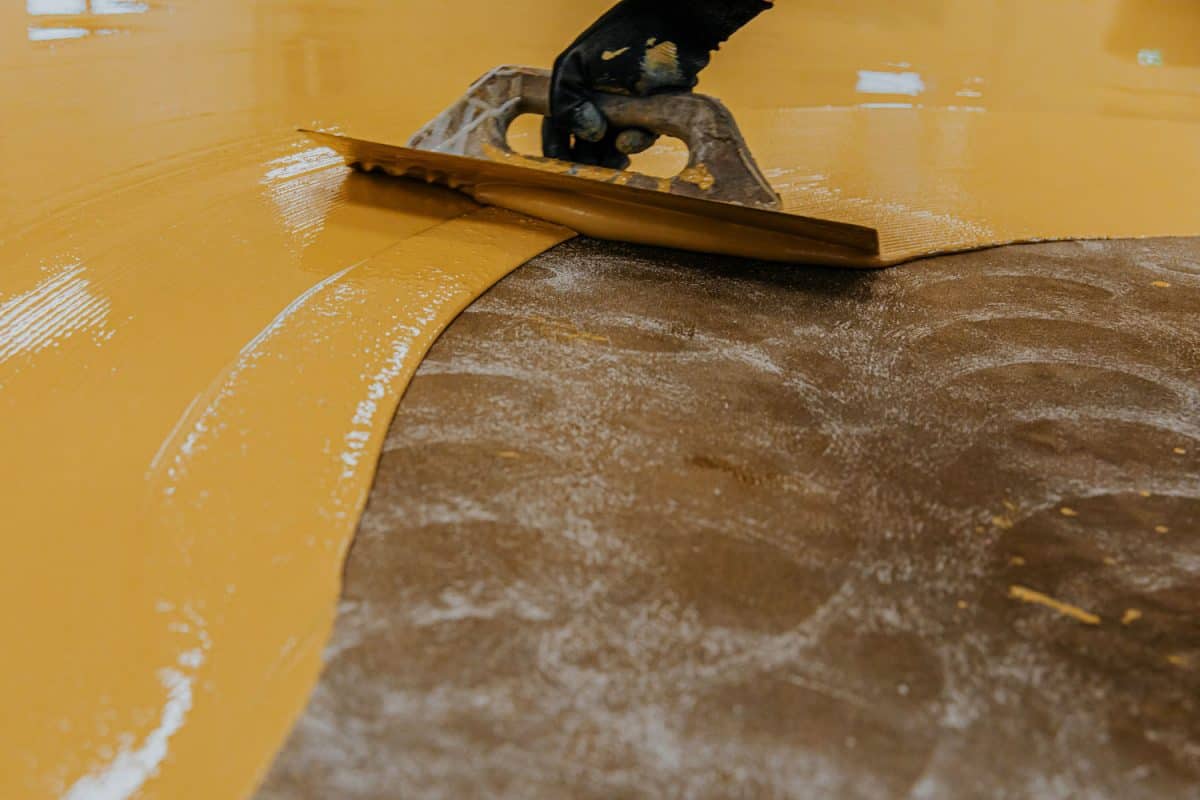 Spreading yellow epoxy on the building floor