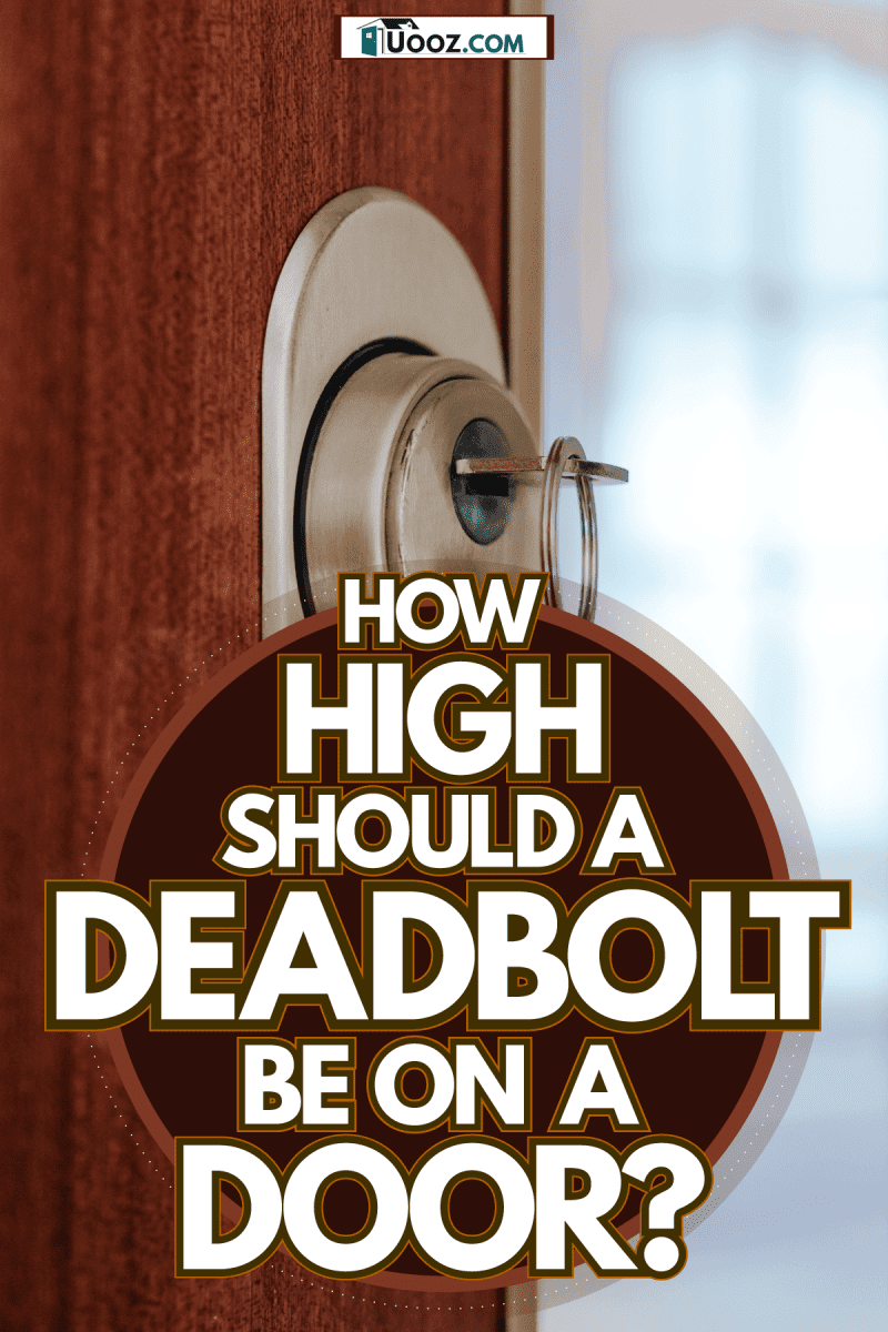 A wooden door with a deadbolt lock and a key stuck on it, How High Should A Deadbolt Be On A Door?