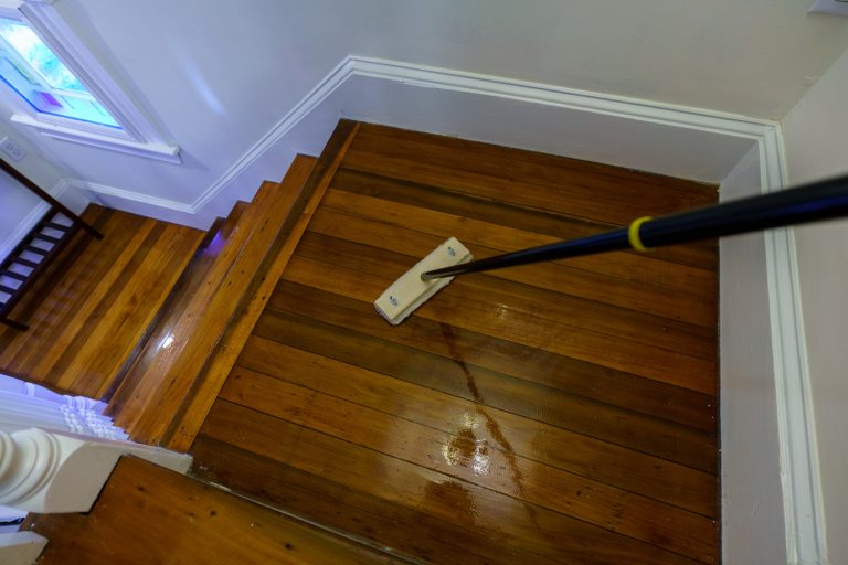 Spreading polyurethane for wood floor restoration with a wool spreader and stick-Polyurethane Floor Too Shiny-What To Do