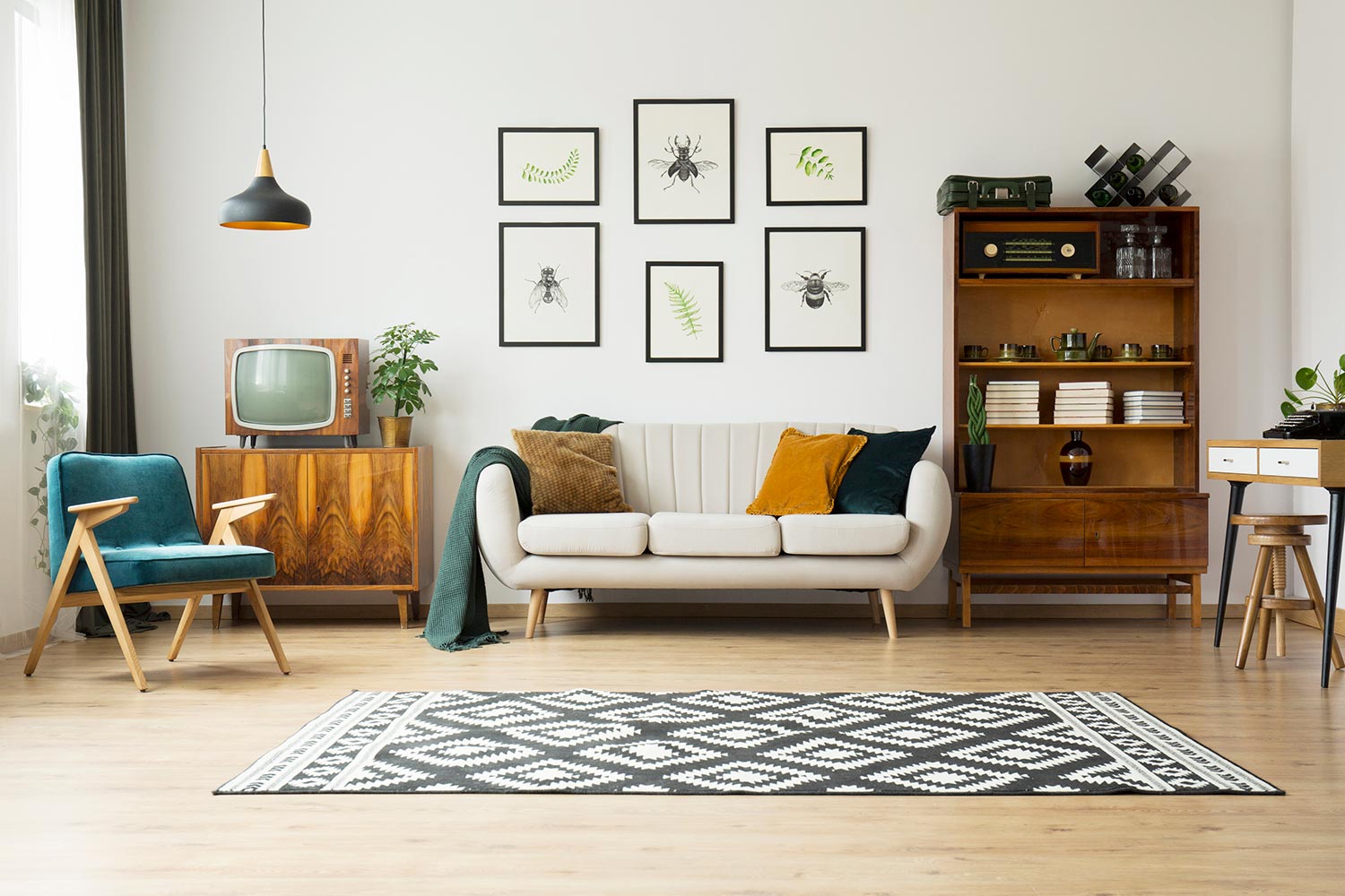 Vintage tv standing on a wooden cabinet next to a comfy couch in a stylish day room