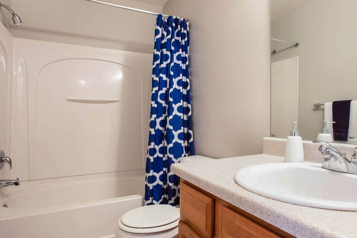 A blue patterned shower curtain for the bathtub