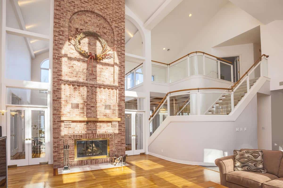 Amazing home interior with brick fireplace and spectacular glass staircase